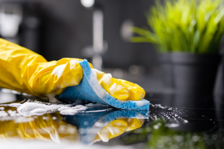 hand wiping kitchen counter with sponge